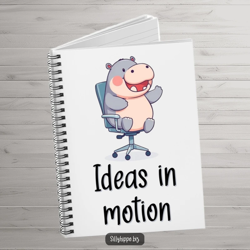 A round hippo gleefully spins on an office chair on the cover of this humorous notebook.